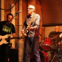 The "Tichy Boys" Featuring a bassist, John Tichy (guitar/vocals), drummer, and Johnny Rabb (vocals), performing at "Still: DQ 2 For Dick Quinn" concert held at The Hangar in Troy, NY, Sunday, October 11, 2015. Series 4/19. Photo taken by Amy L. Modesti with her Canon Rebel SL1 Digital SLR Camera. (C): Amy Modesti, 2015
